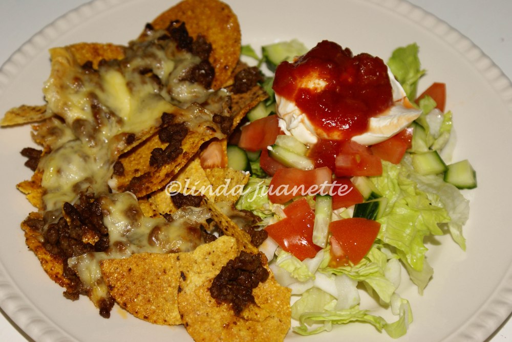 Sprø nachos med tacokjøtt og smelta ost smaker veldig godt sammen med salat, rømme og salsa.