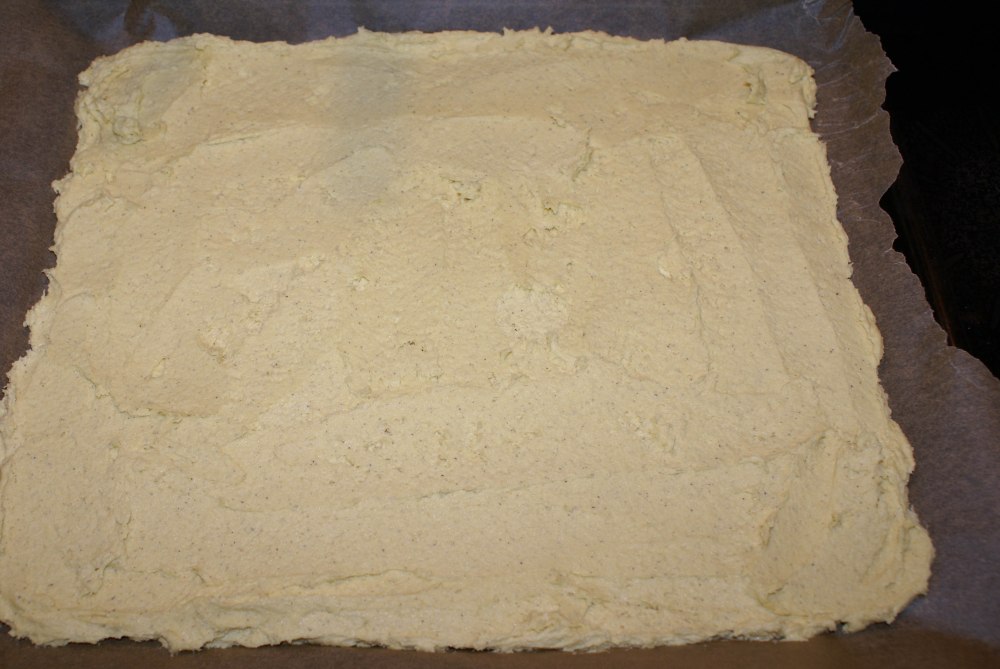 Bre deigen utover en bakepapirkledt langpanne.