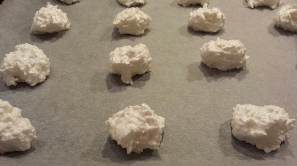 Sett makronene på bakepapirkledt stekeplate med en stor teskje.