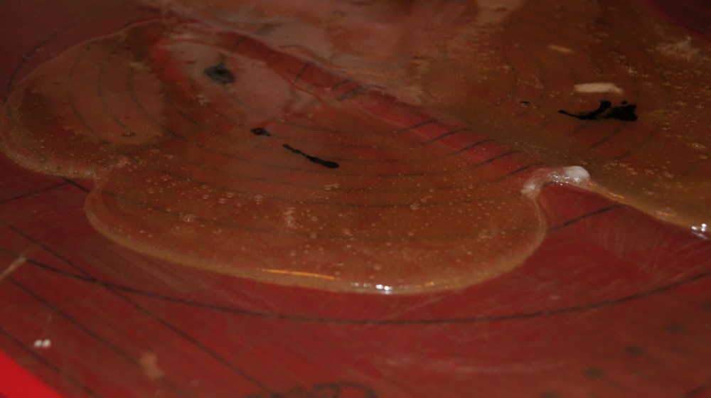 Hell massen ut på teflonmatten. HUSK at massen er varm!!! Ha farge i den flytende sukkermassen og elt massen rundt til fargen er oppløst.