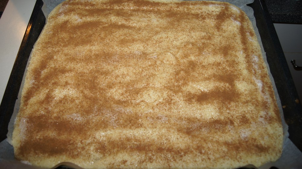 Strø sukker og kanel over kakerøren før den steikes.